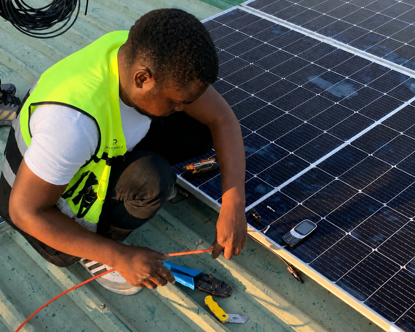 RACHFLO technicians working on a commercial rooftop solar array