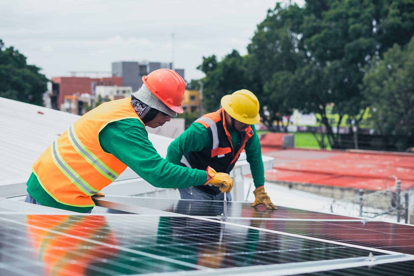 Technicians installing solar panels on a roof